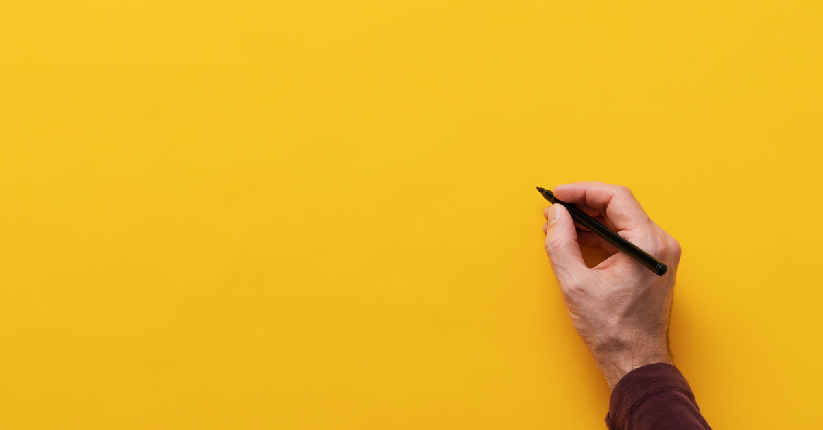 yellow background with hand about to write on it