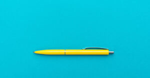a yellow pen on a turquoise background