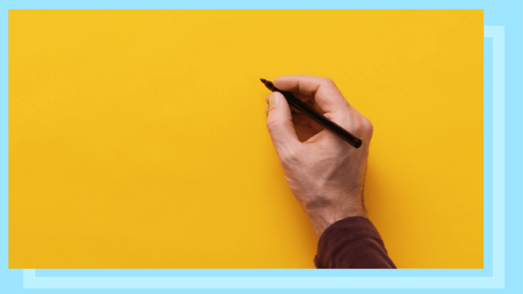 A hand writing on a yellow background