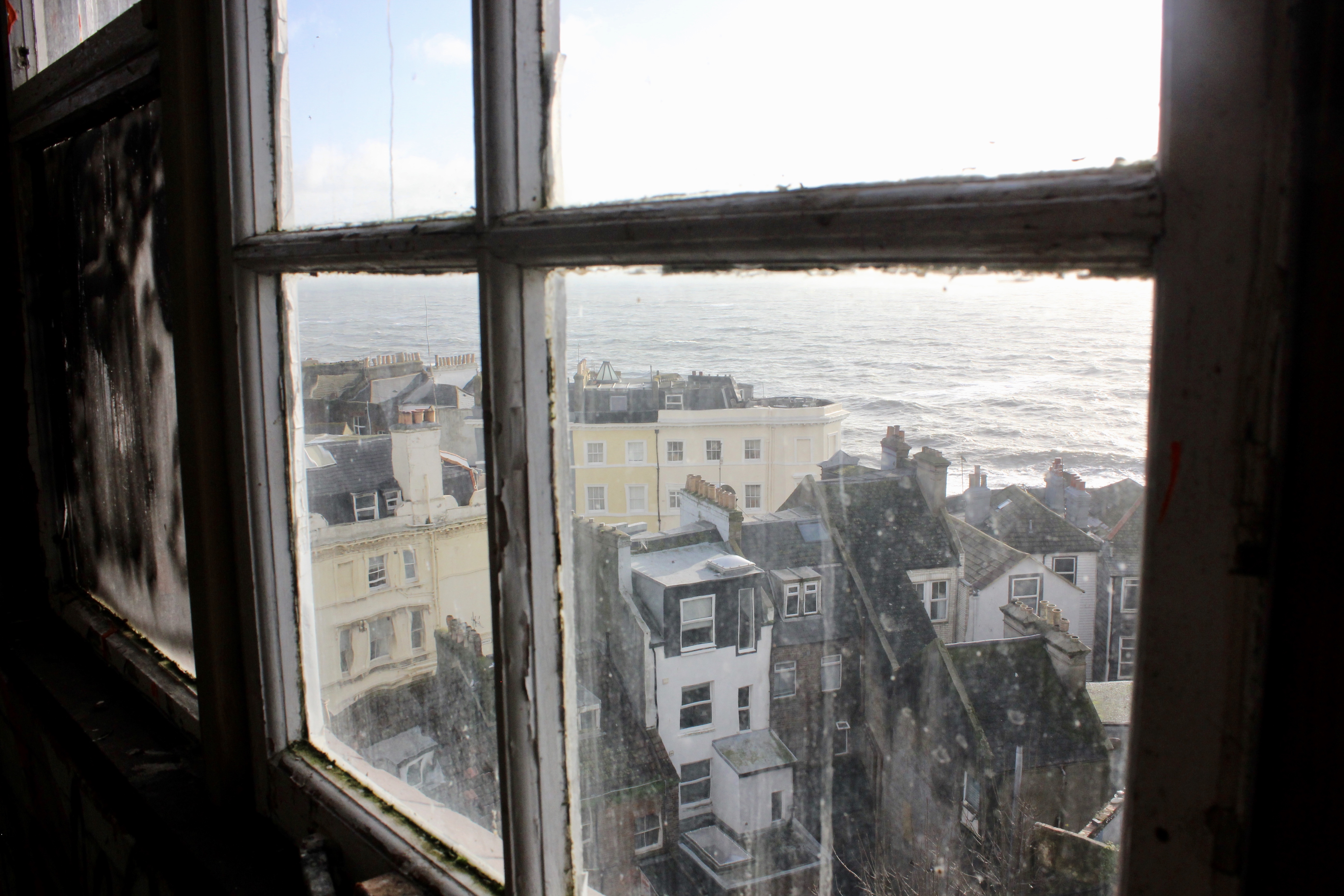 Looking out of a window at Hastings, the sea in the distance