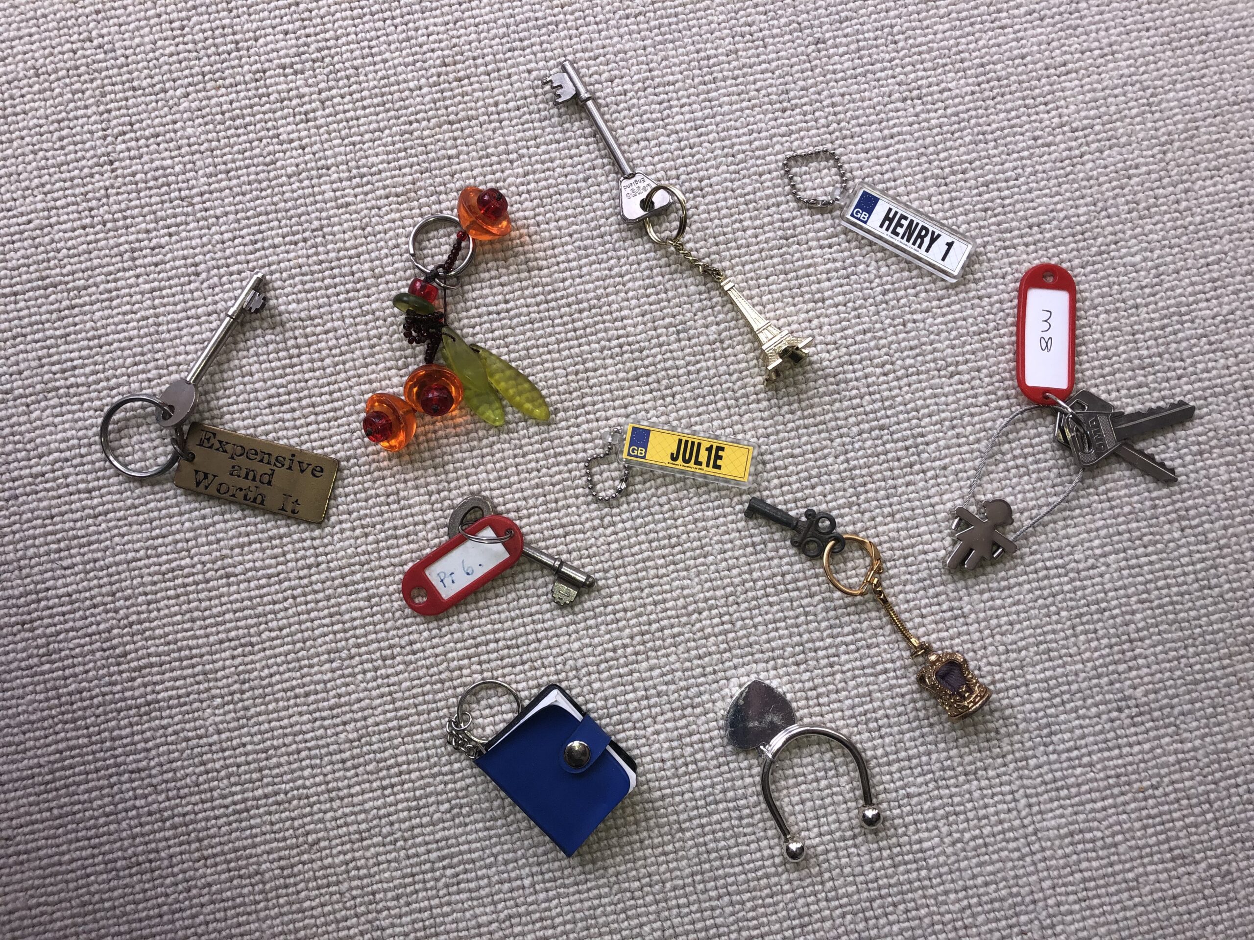a variety of different keys laid out on a carpet floor
